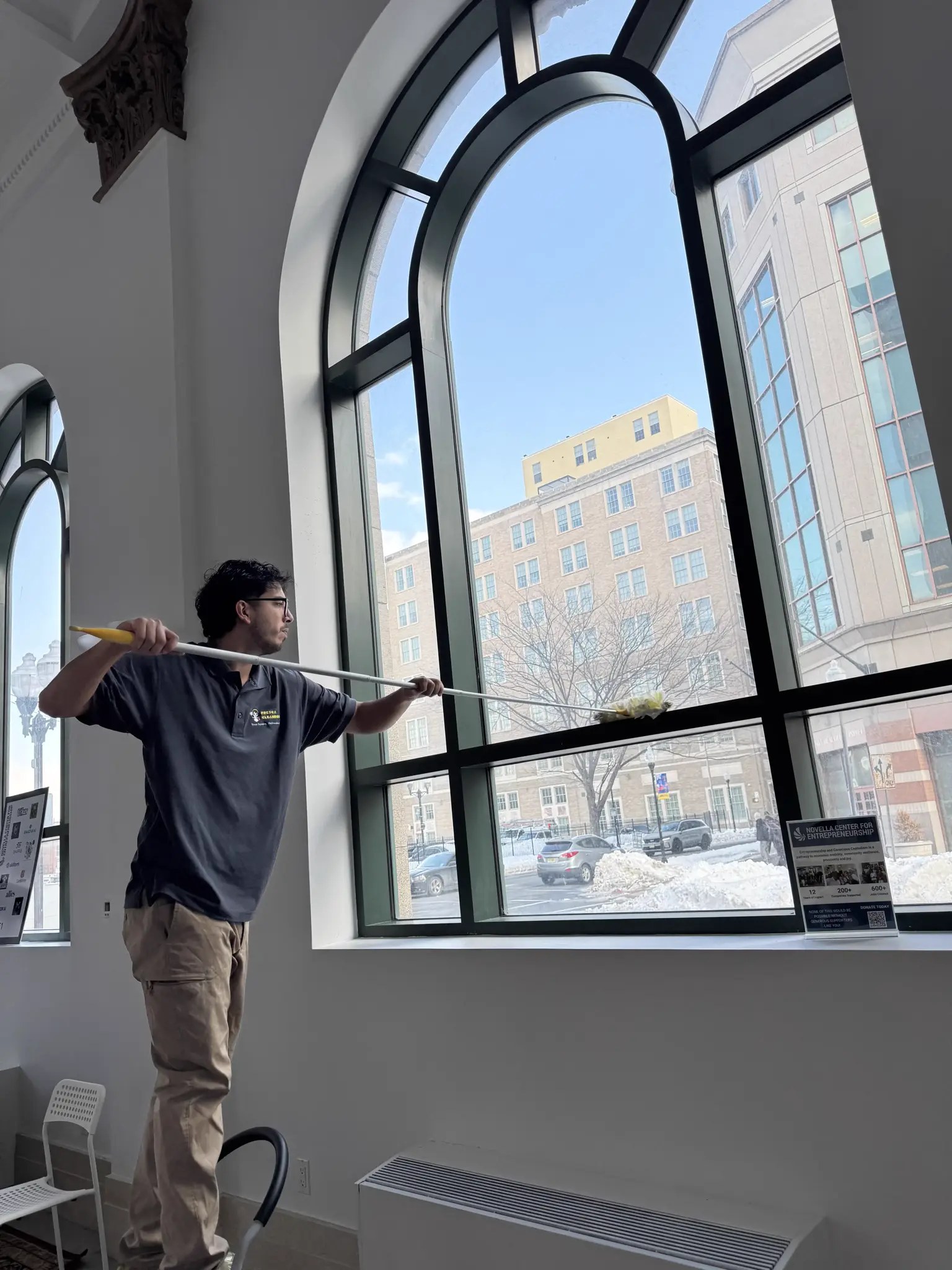 Alexander Morales of Fresca Cleaners working on a window